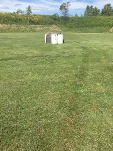 white barrels 40 feet away with two black dots of paint